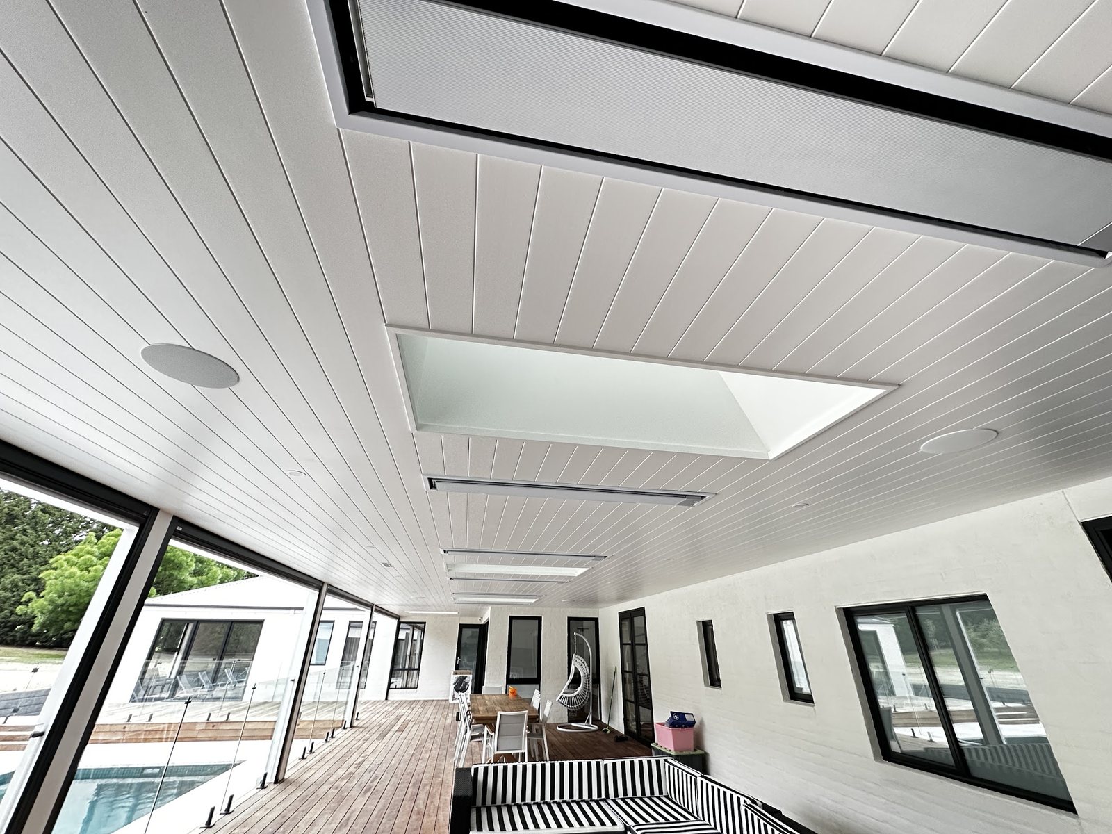 Outdoor alfresco area with a freshly painted white lining-board ceiling and skylight