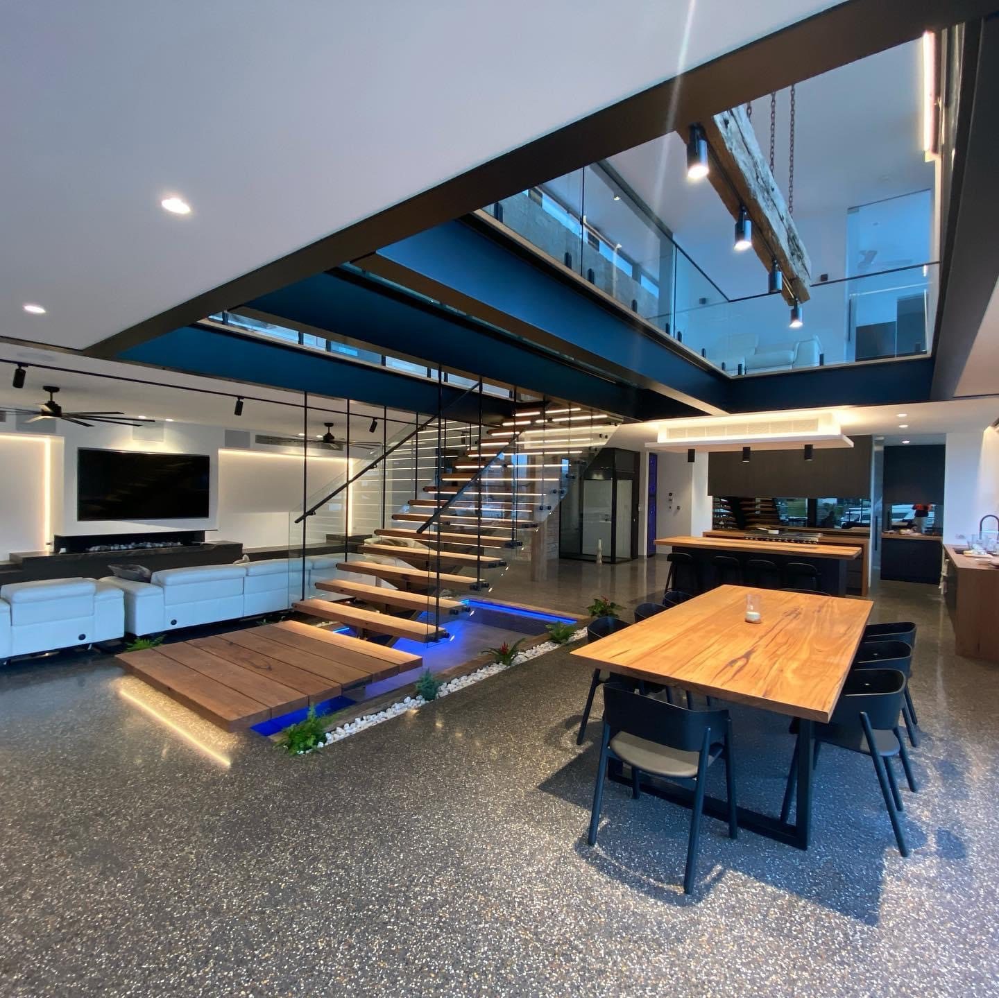 Double-height living space with a painted navy feature bridge and white ceilings